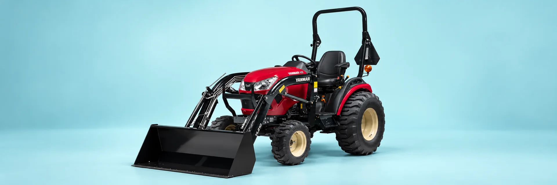 Yanmar SA425 — Open station, raised ROPS, industrial tires and front loader with bucket.